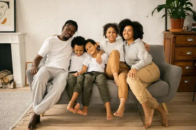 a joyful and happy family seated together in one couch